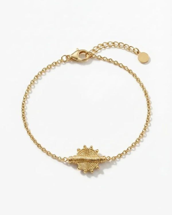 Gold bracelet with a unique clasp design on a white background