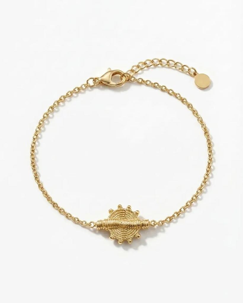 Gold bracelet with a unique clasp design on a white background
