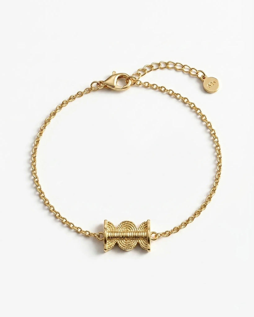 Gold bracelet with a unique clasp design on a white background
