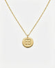 Gold necklace with a round pendant on a white background