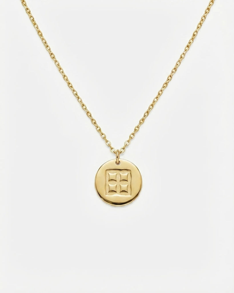 Gold necklace with a round pendant on a white background

