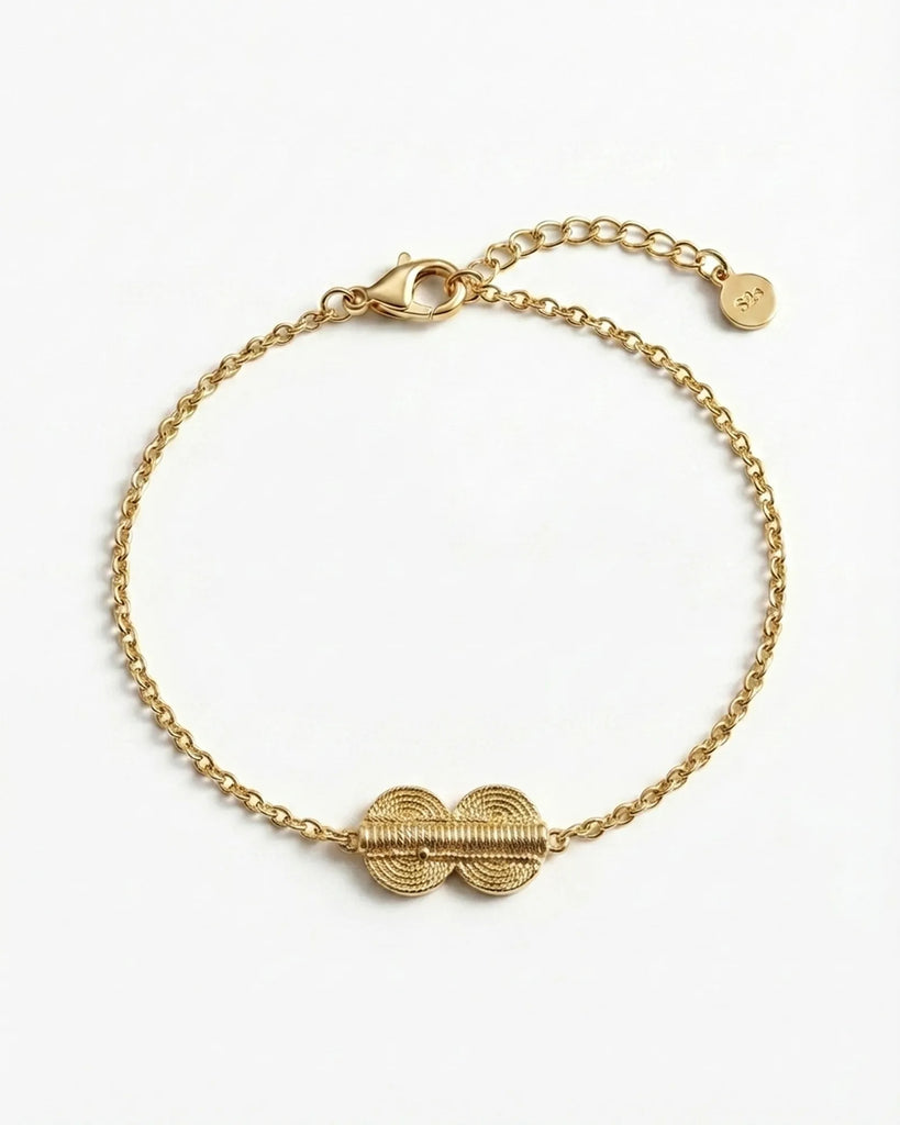 Gold bracelet with a unique clasp design on a white background
