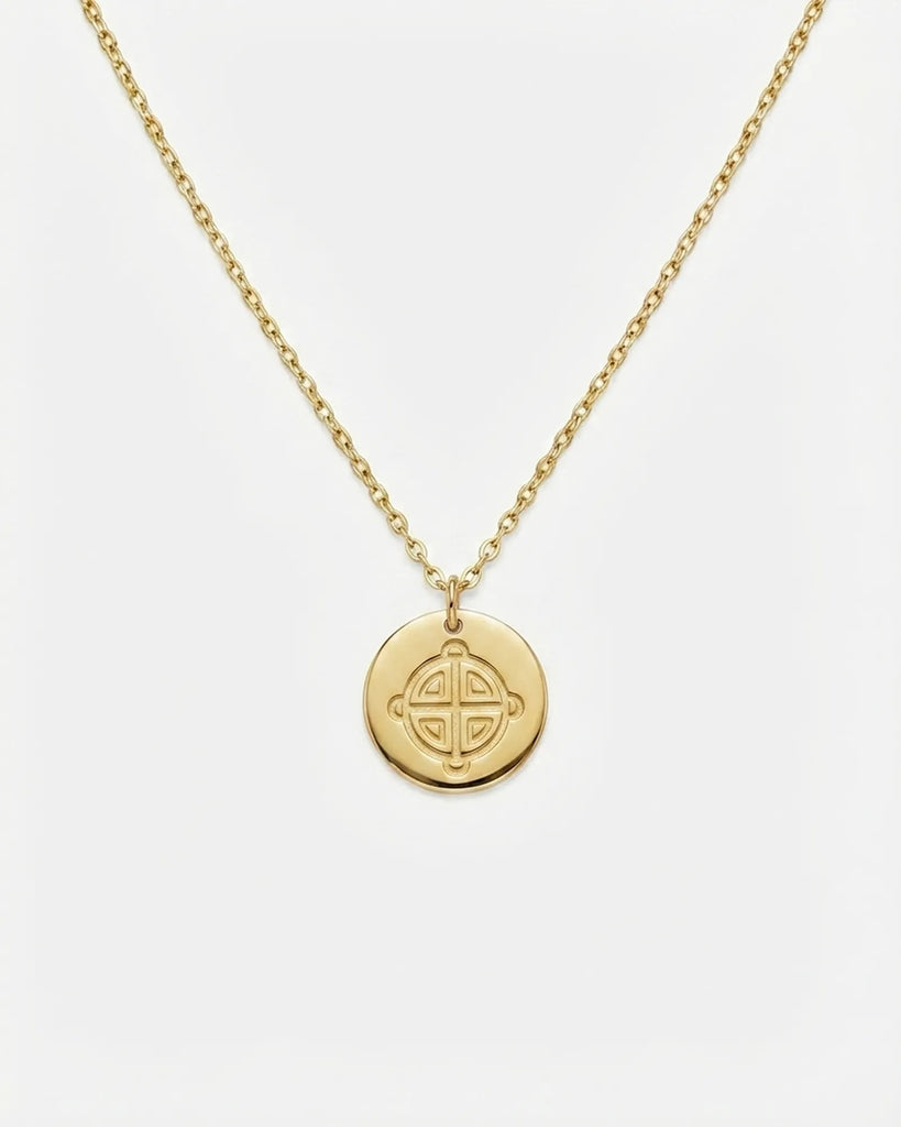 Gold necklace with a round pendant on a white background
