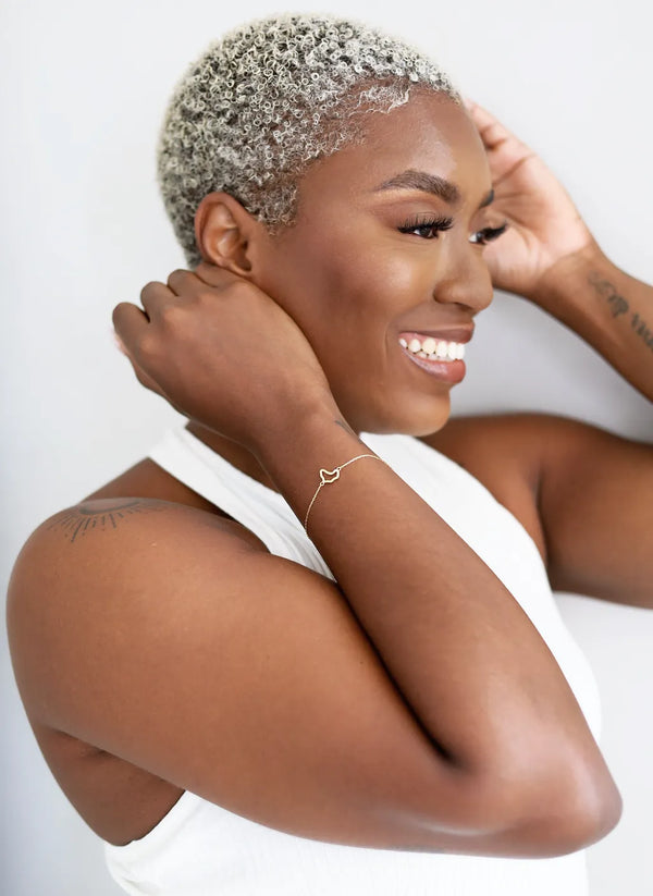 Woman with short, styled hair smiling against a white background