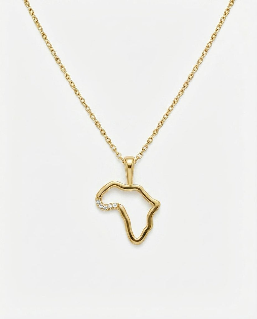 Gold necklace with a pendant shaped like the African continent on a white background
